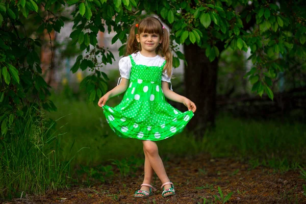 少女晴れた夏の日の緑豊かな庭園の中を歩く — ストック写真