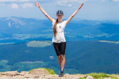 Tepenin üstünde genç mutlu kadın zevk güzel manzara gökyüzü ve dağlar, özgürlük ve uyum kavramı