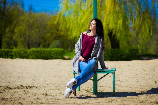 Jonge Brunette Vrouw Spijkerbroek Zittend Bank Warme Zonnige Dag — Stockfoto