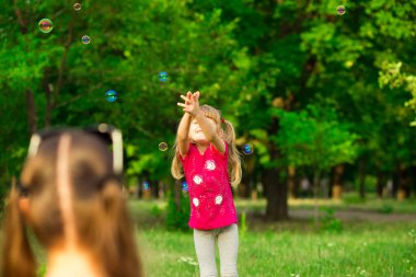 Genç Anne ve küçük kızı sabun köpüğü ile parkta oynarken. Aile, ebeveynlik, çocukluk seviyorum