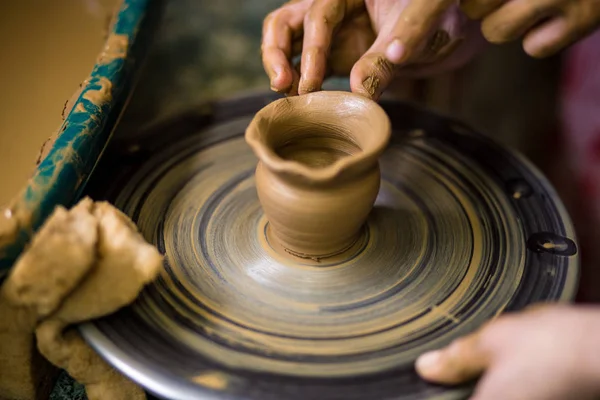 Sculpts in clay pot closeup. Modeling clay close-up. Caucasian man making vessel daytime of white clay in fast moving circle. Art, creativity. Ukraine, cultural traditions. Hobbies