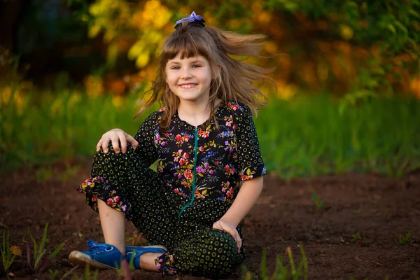 夕暮れ時の公園を歩いて愛らしい笑みを浮かべて少女の肖像画 秋が来ている幸せな子供 — ストック写真