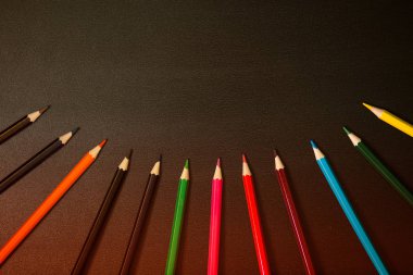 Siyah kara tahta arka plan üzerinde renkli kalemler topluluğu