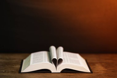 Kitap sayfa koyu arka plan ile kalp şeklinde. Kitap kavramsal yürekten. Kopya alanı