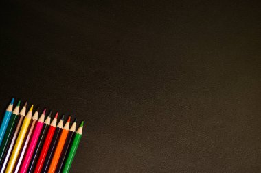 Siyah kara tahta arka plan üzerinde renkli kalemler topluluğu
