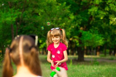 Genç Anne ve küçük kızı sabun köpüğü ile parkta oynarken. Aile, ebeveynlik, çocukluk seviyorum