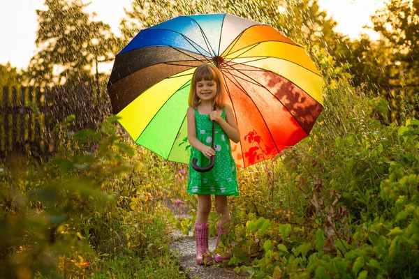 夏の雨の下で色とりどりの傘で歩く幸せな子供女の子 — ストック写真