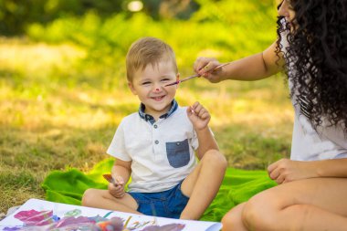 Anne ve oğlu yüzlerini açık boya. Mutlu aile kavramı
