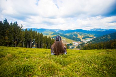 Arkadan görünüşü uzun yürüyüşe çıkan kimse kadın yalan dağın zirvesinde çimenlerin üzerinde. Seyahat kavramı