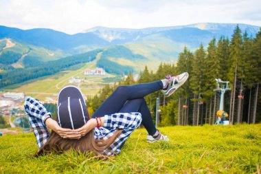 Arkadan görünüşü uzun yürüyüşe çıkan kimse kadın yalan dağın zirvesinde çimenlerin üzerinde. Seyahat kavramı