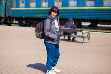 Tren istasyonunda sırt çantası ile 60 yaşındaki kadın. Seyahat kavramı