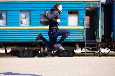 Tren istasyonunda çalıştırmak çuval olan genç adam. Tren