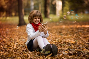 Çocuk ve teknoloji kavramı - sonbahar Parkı'nda görüntülü görüşme sahip smartphone ile kız