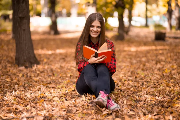 Beautiful girl in autumn park reading book. Girl reading book