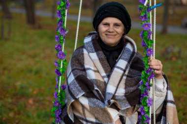 Sonbahar hızıyla battaniye otur kaplı çekici orta yaşlı kadın