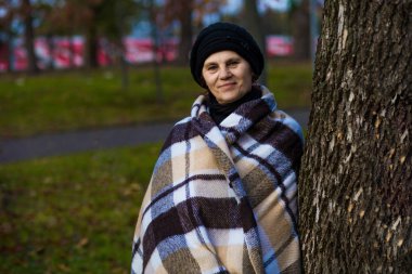 Çekici orta yaşlı kadın ile battaniye yürüyüş sonbaharda kaplı. 