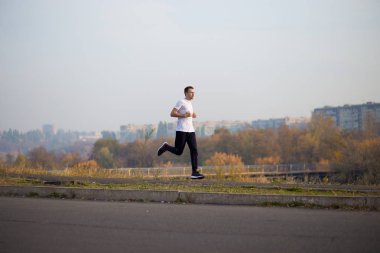 Adam sonbahar sabahı koşar. Sağlıklı yaşam tarzı kavramı