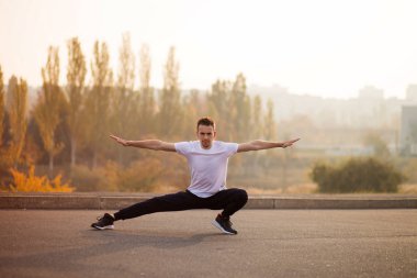 Genç erkek koşucu sporcu antrenmanı yapıyor ve şehir dışında spor yapıyor.