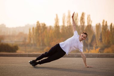 Genç erkek koşucu sporcu antrenmanı yapıyor ve şehir dışında spor yapıyor.