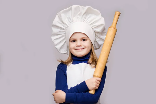 子供を調理します シェフの制服を着た幸せな少女は 麺棒は 白い背景で隔離を保持しています 子供のシェフ — ストック写真