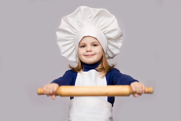 子供を調理します シェフの制服を着た幸せな少女は 麺棒は 白い背景で隔離を保持しています 子供のシェフ — ストック写真