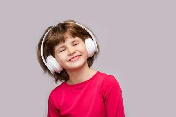 Энергетическая Девочка Наушниками Слушает Музыку Закрытыми Глазами Белом Фоне Студии — стоковое фото