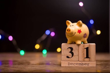 Mali yıl sonu, kumbara garland bokeh ile koyu arka plan üzerinde ile 31 Aralık takvim tarihi.
