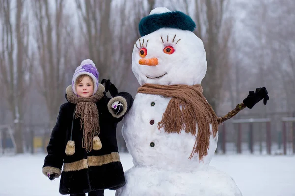 Маленькая Веселая Девочка Рядом Большим Смешным Снеговиком Милая Маленькая Девочка — стоковое фото