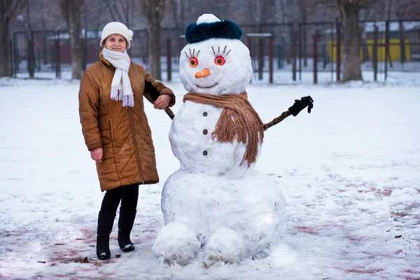 Mulher Sênior Feliz Esculpir Abraçar Grande Boneco Neve Real Parque — Fotografia de Stock