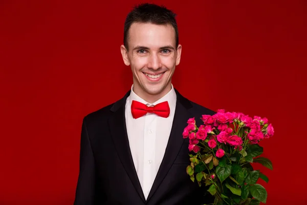 Stilig Mann Dress Som Holder Bukett Med Blomster Med Rød – stockfoto