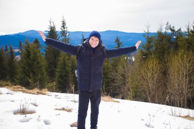 Mutlu genç çocuk kar ile dağın tepesinde ağaçlar güzel vadi manzaralı hayran kaplı