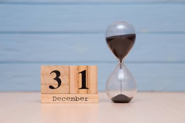 31 Aralık ahşap takvim ve mavi arka plan ile kırmızı alarm saati ayarlayın. Saati göster gece yarısına 5 dakika