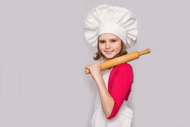 Cook çocuklar. Mutlu küçük kız Şef üniformalı oklava beyaz arka plan üzerinde izole tutar. Çocuk Şef.