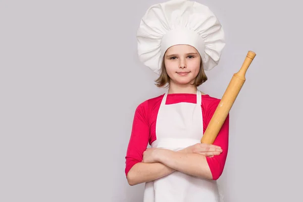 子供を調理します シェフの制服を着た幸せな少女は 麺棒は 白い背景で隔離を保持しています 子供のシェフ — ストック写真