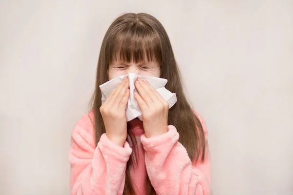 Little girl with runny nose wipes her nose, health concept