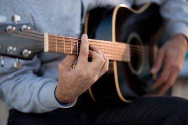 gitar çalarken basamaklarında oturan genç adam