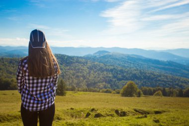 Dağlar manzarayı tepenin üstüne şapkalı kadın turist. Seyahat kavramı