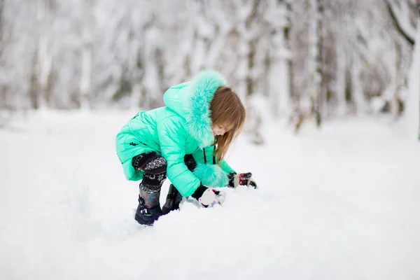 雪の中で美しい冬の公園で楽しんで面白い女の子 — ストック写真