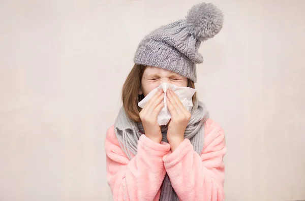 Little girl with runny nose wipes her nose, health concept