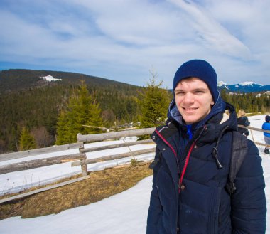 Mutlu genç çocuk kar ile dağın tepesinde ağaçlar kış günü güzel vadi manzaralı hayran kaplı