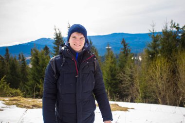 Mutlu genç çocuk kar ile dağın tepesinde ağaçlar kış günü güzel vadi manzaralı hayran kaplı