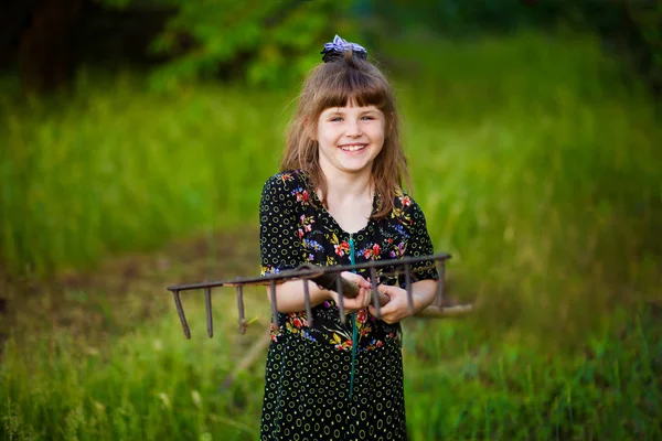 little girl help parents in garden with rake