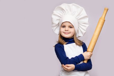 Cook çocuklar. Mutlu küçük kız Şef üniformalı oklava beyaz arka plan üzerinde izole tutar. Çocuk Şef.