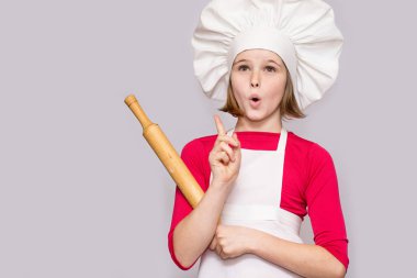 Cook çocuklar. Mutlu küçük kız Şef üniformalı oklava beyaz arka plan üzerinde izole tutar. Çocuk Şef.