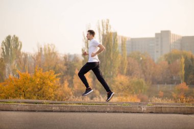 Adam sonbahar sabahı koşar. Sağlıklı yaşam tarzı kavramı