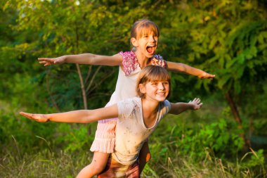 Yaz parkta oynayan iki küçük kız uçmak. Dostu aile kavramı.