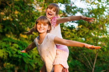 Yaz parkta oynayan iki küçük kız uçmak. Dostu aile kavramı.