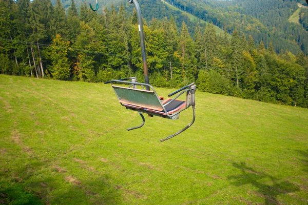 空スキー リゾートのリフト 山と緑の木々 と芝生の夏の丘 — ストック写真