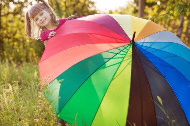 Mutlu çocuk kız yürümek Sonbahar yağmur altında çok renkli şemsiye ile