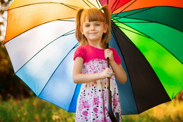 秋の雨の下で色とりどりの傘で歩く幸せな子供女の子 — ストック写真